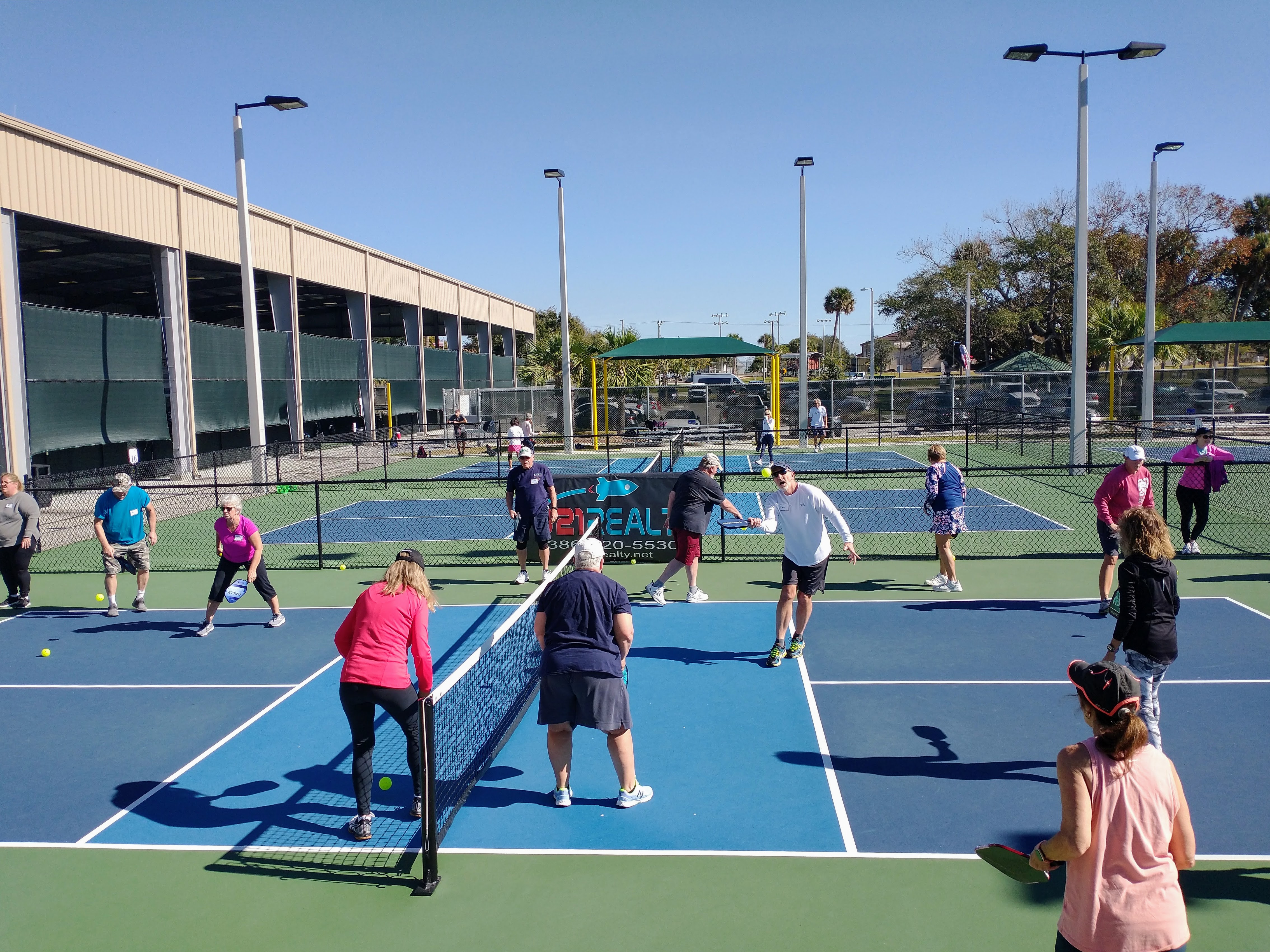 A large PB101 beginner group learning across several courts